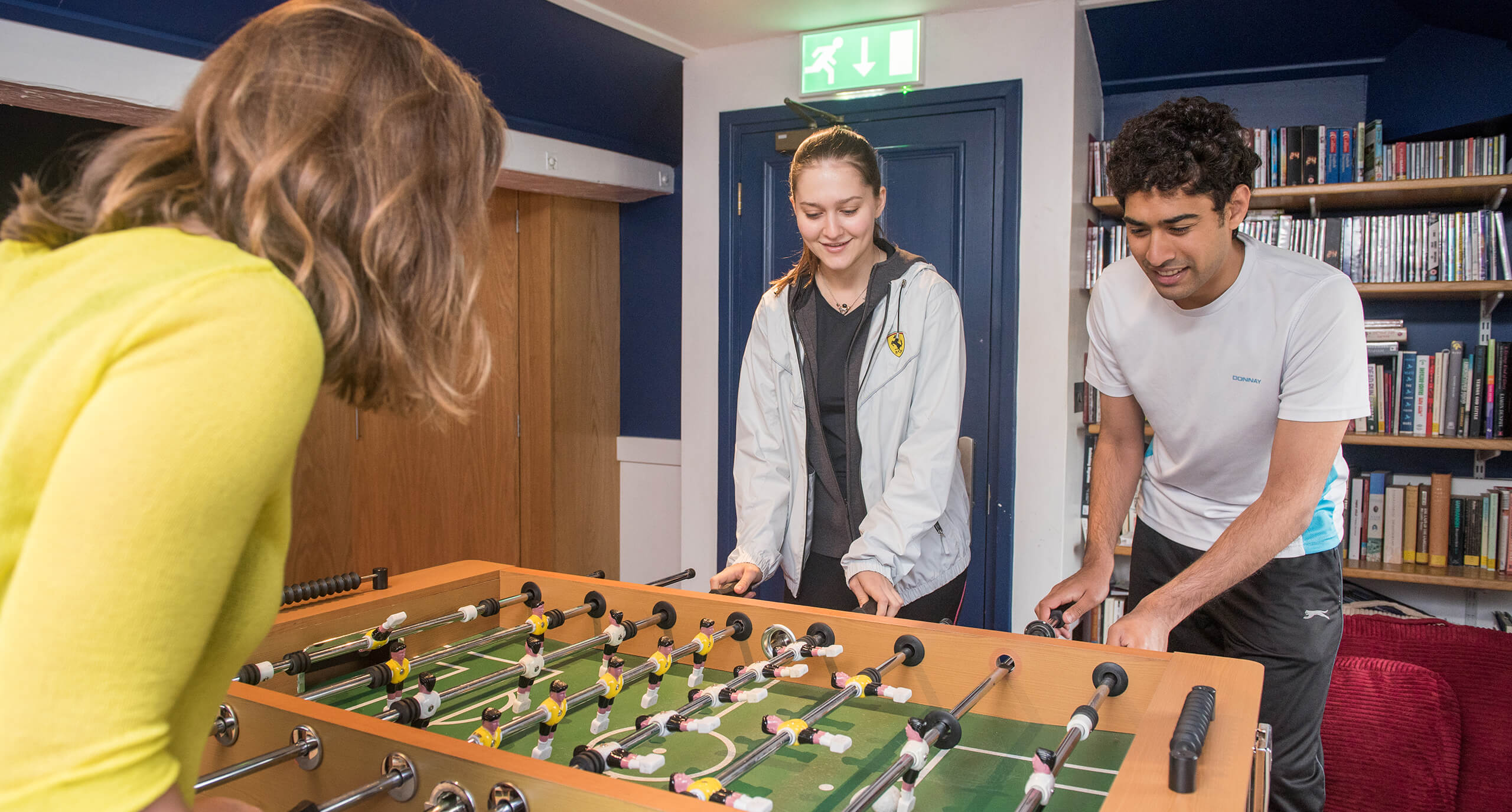 Students play against each other on a football table in the Hayloft