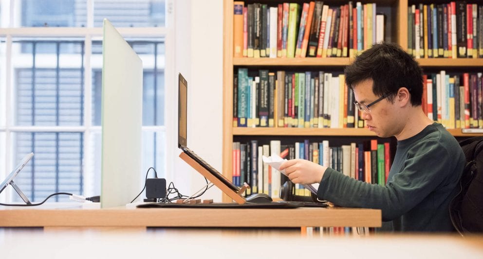 Student studying on laptop in the library