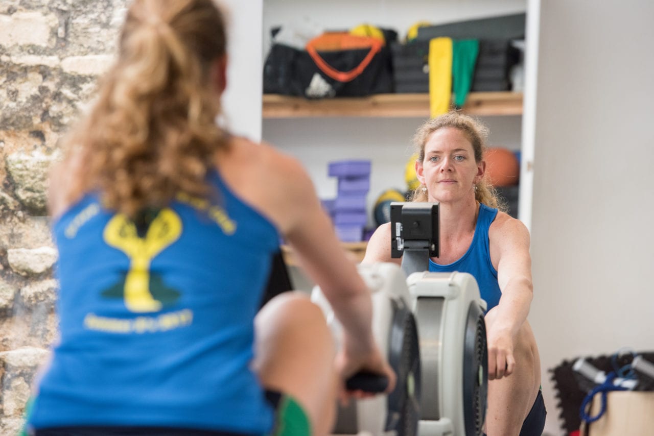 Student on a rowing machine in college gym