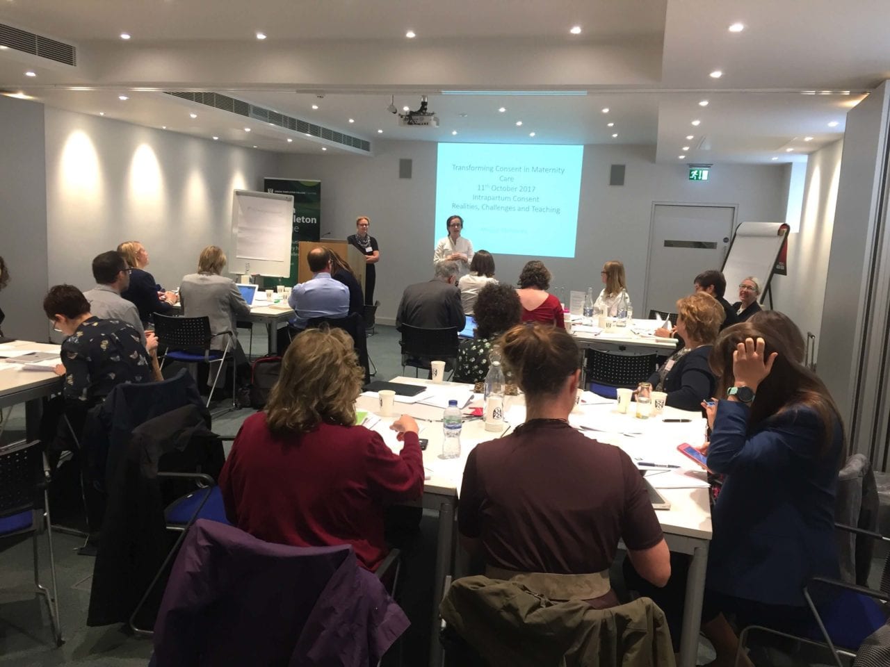 People grouped around tables in the Green Templeton lecture theatre as a speaker presents from the lectern