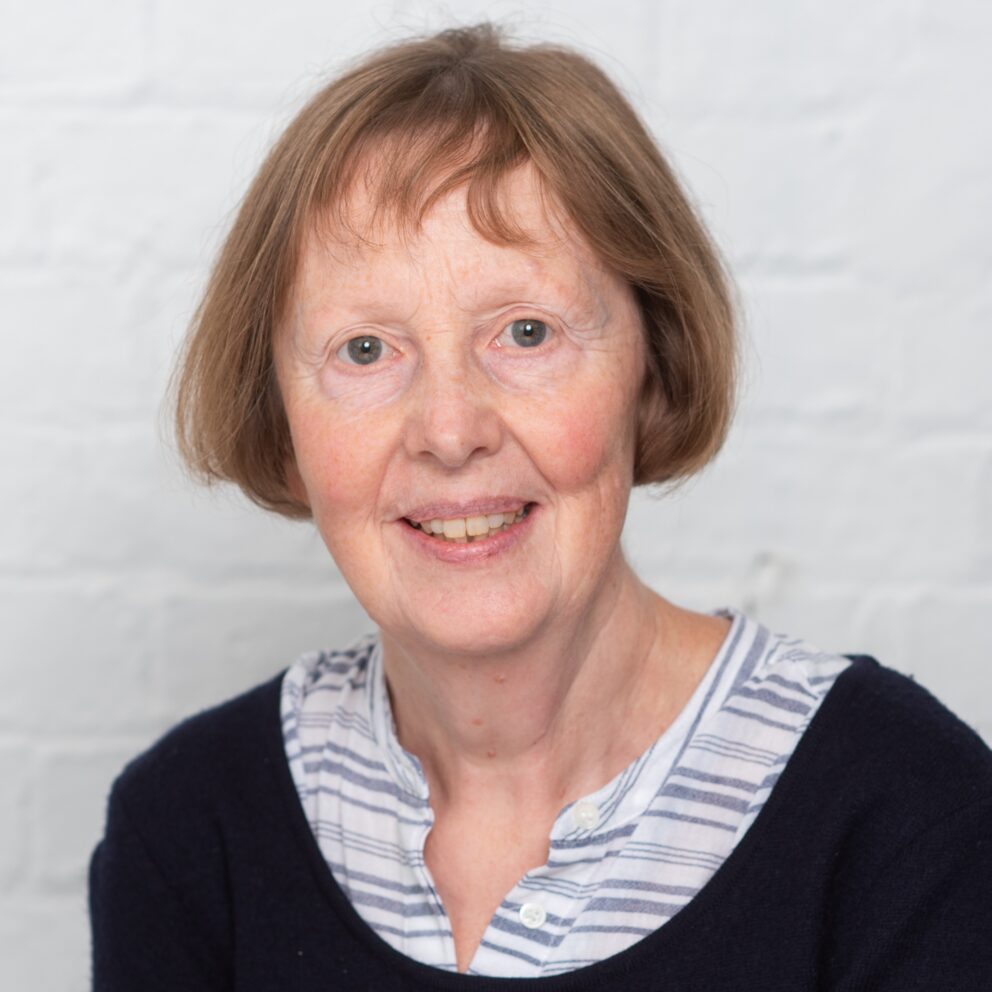 Sarah J Darby headshot in front of white wall