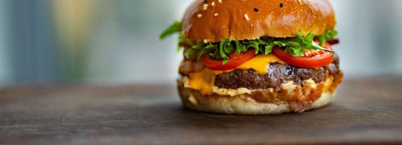 Gooey cheese oozes from a fat burger packed with lettuce and tomato
