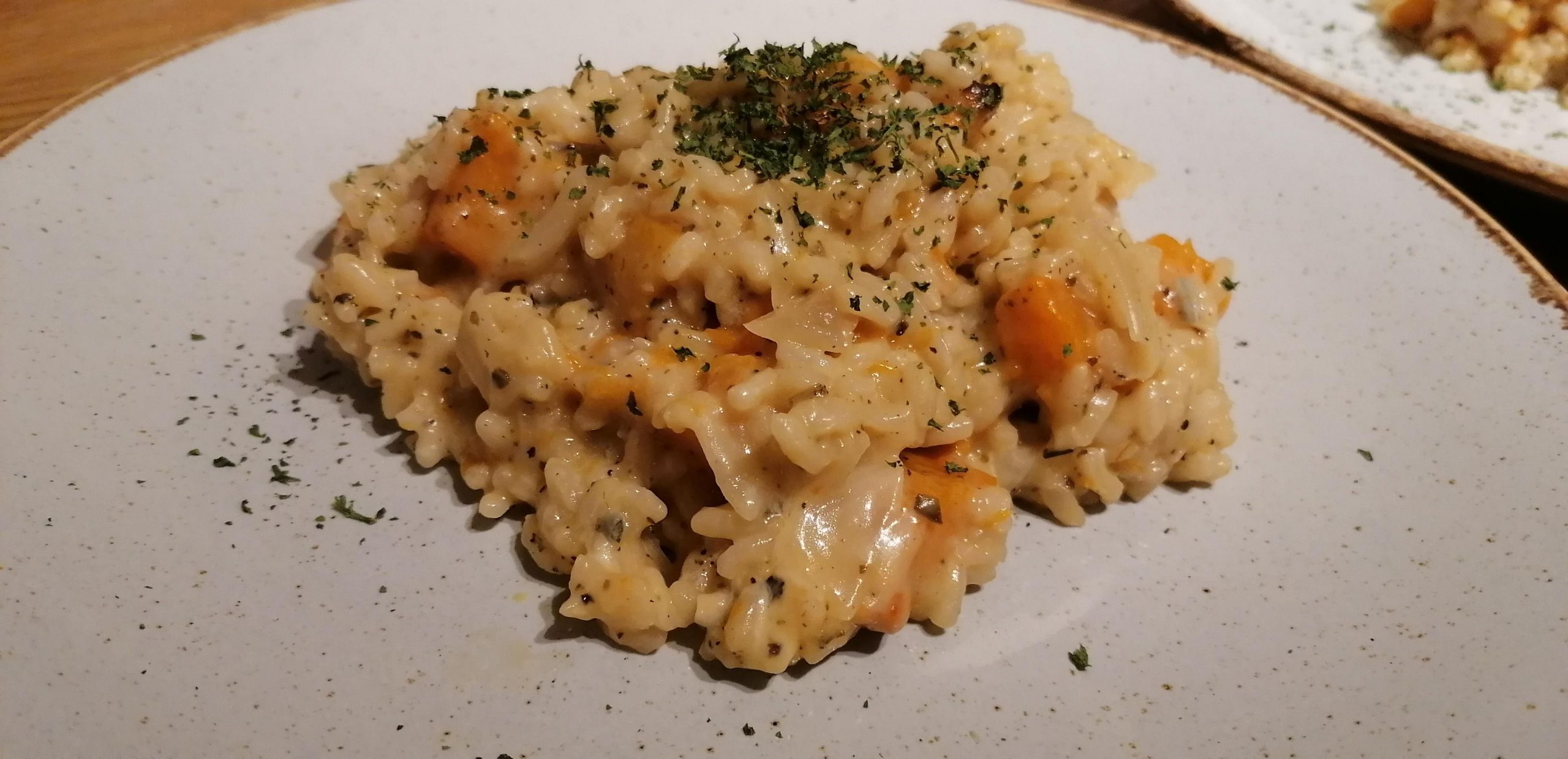 Fluffy, creamy and delicious roast butternut squash risotto with a sage garnish on a white plate
