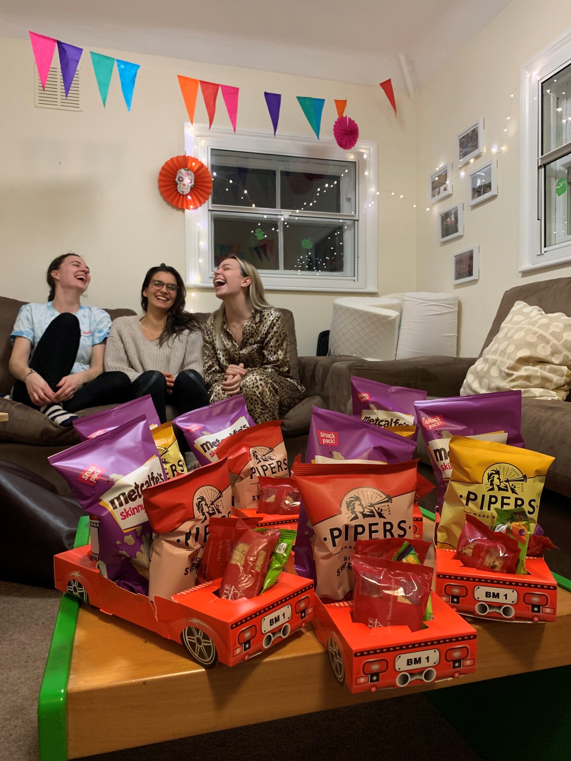 Students laughing as they enjoy a movie night event kit in their household