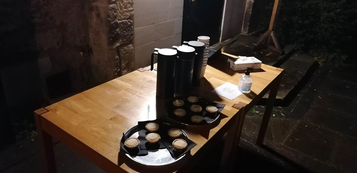 Plates of mince pies and jugs of mulled wine on a table in the college Quad