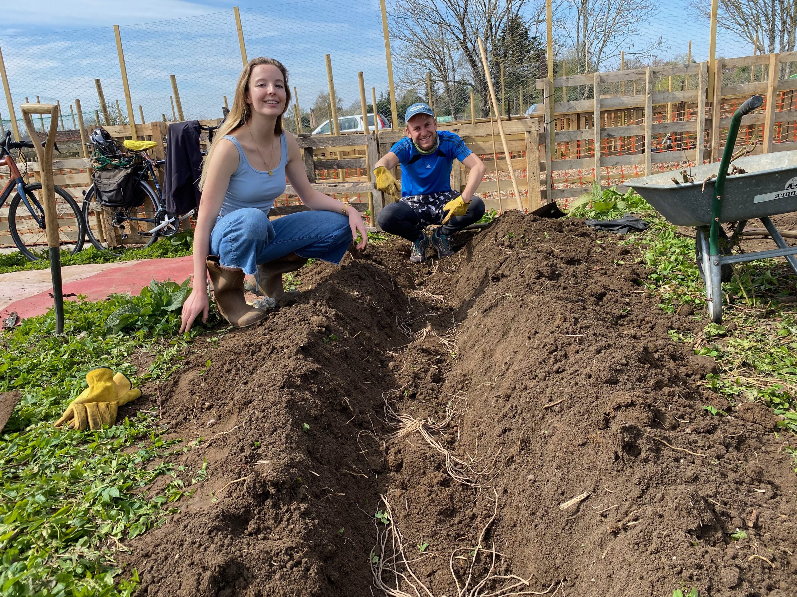 Two Green Templeton College Allotment Club team members pose next to a freshly dug bed ahead of planting raspberries