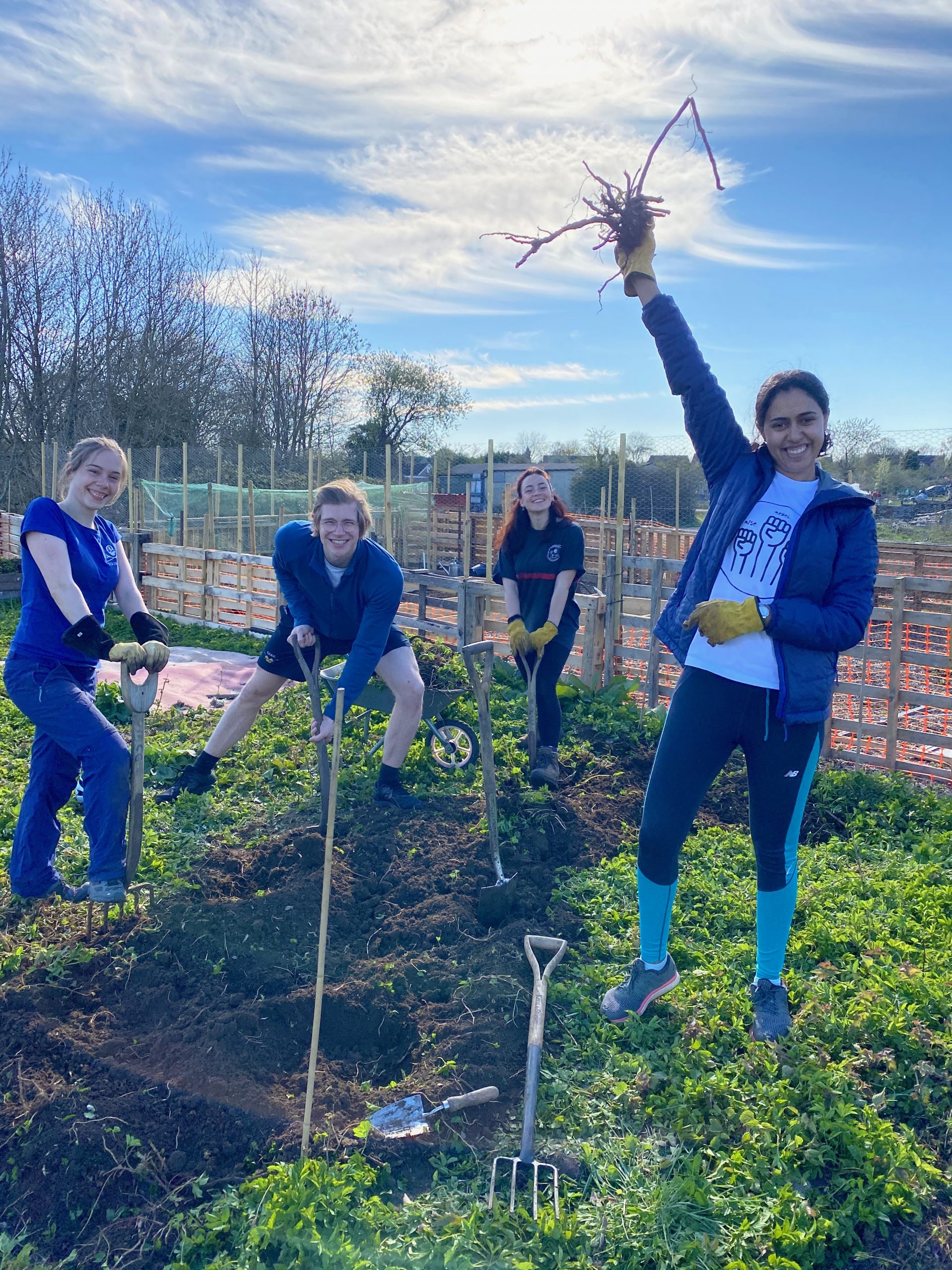 Allotment club members enjoy the sunshine as they pose for a photo on the site mid-dig