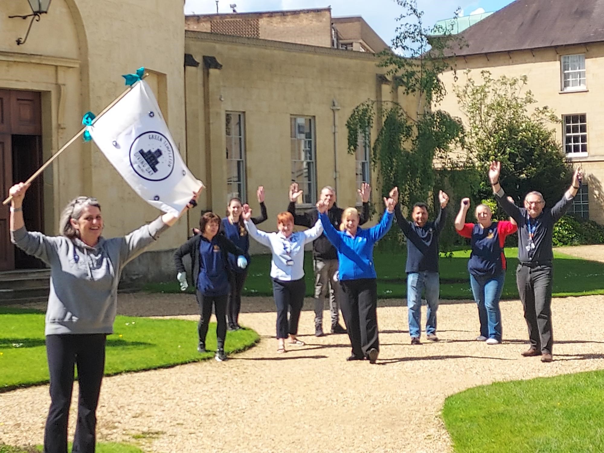Staff members throw their hands in the air outside the Radcliffe Observatory