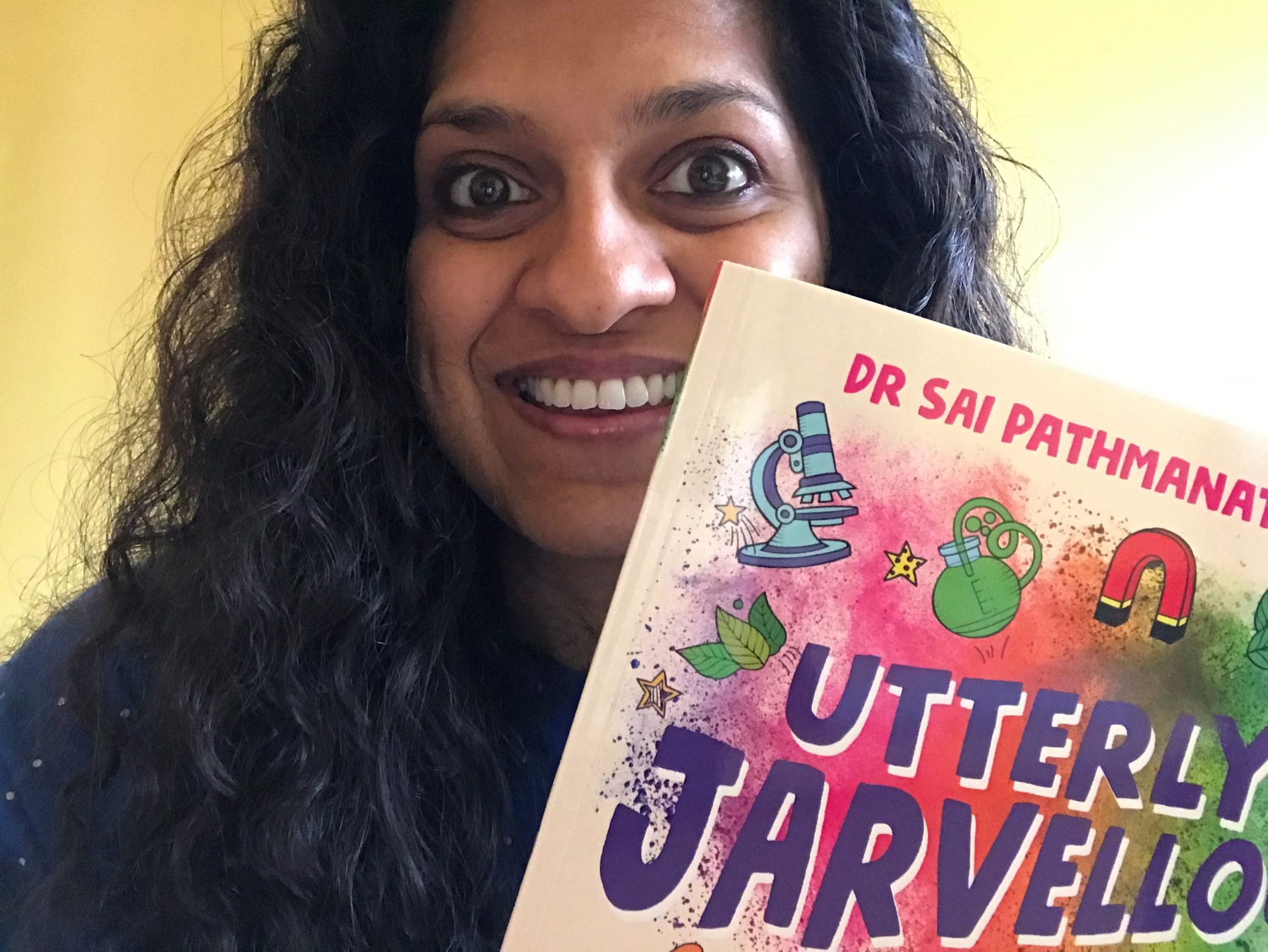Dr Sai Pathmanathan holding a copy of her book 'Utterly Jarvellous'