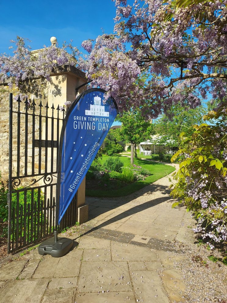 A blue flag with the words 'Green Templeton Giving Day' flies on a gate outside the Radcliffe Observatory