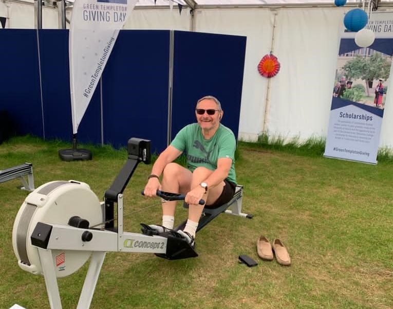 Librarian Richard Turner smiles as he rows in the sunshine on a rowing machine at college