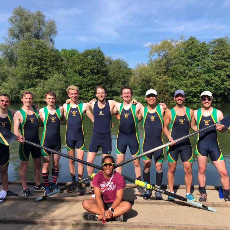 Rob Ferritto and the Green Templeton College Men's Boat Club pose with their oars on the riverside during Summer Torpids 2021