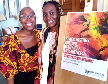 Two guests pictured by poster for Maarifa book collection