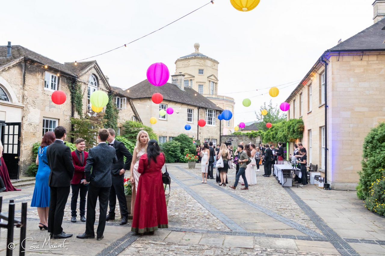 Past Ball guests mingling in quad with Observatory behind