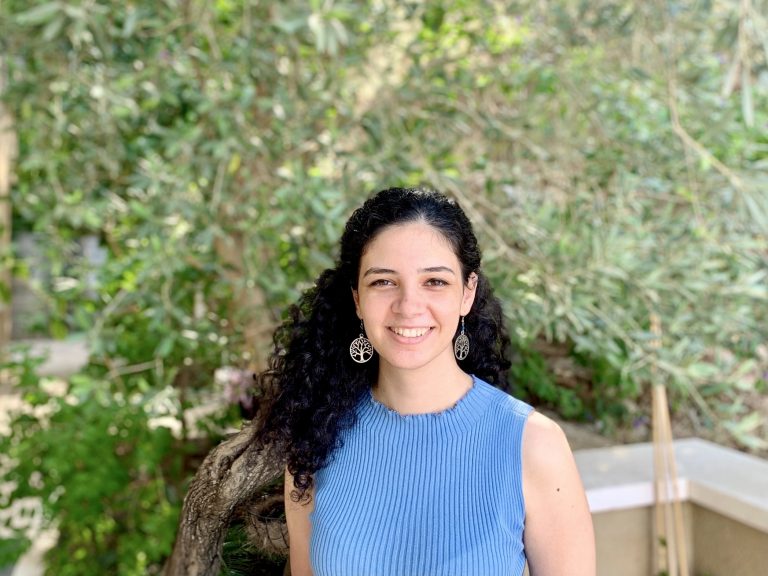 Lamma Mansour wearing a blue top stood in front of a tree