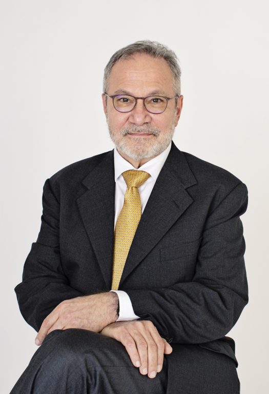 David Matchar headshot in dark suit, white shirt and yellow/gold tie