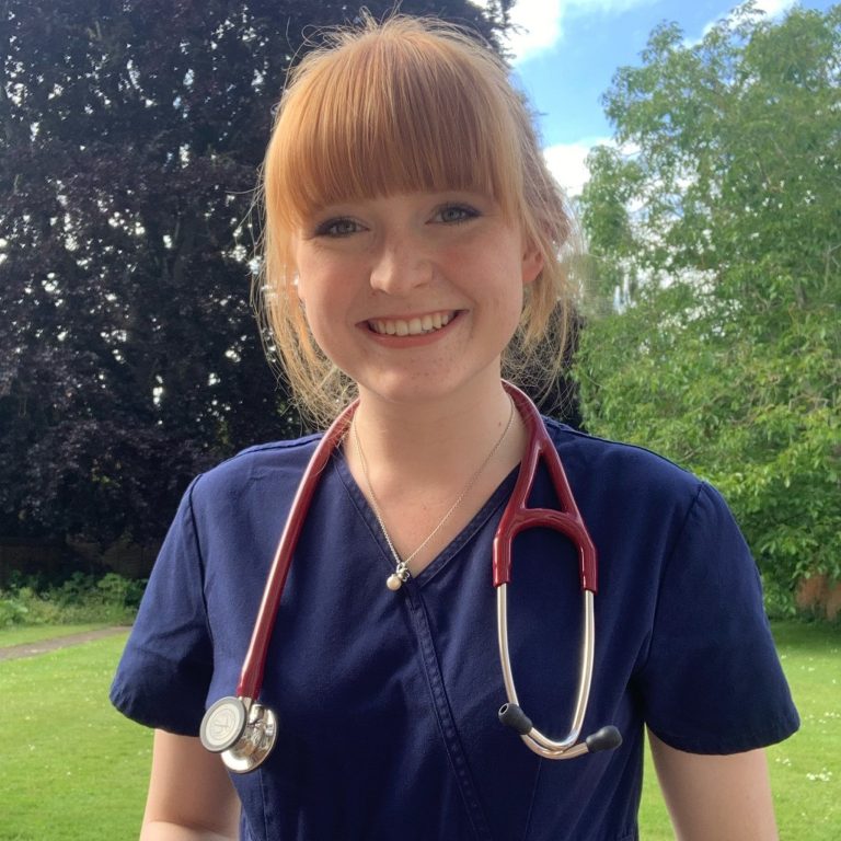 Emily Morris with stethoscope around neck in gardens 