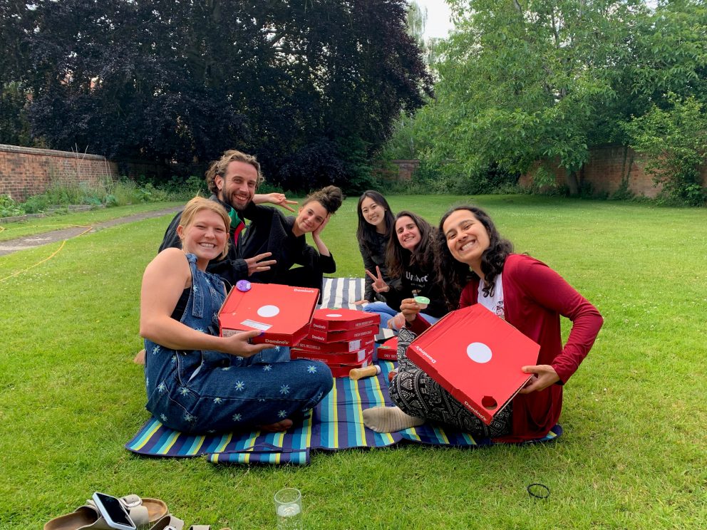 Students in garden with pizza boxes