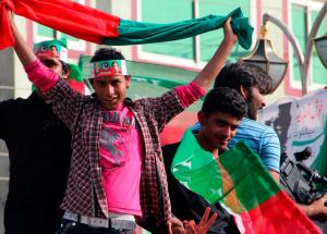 Young men hold their country's flags above their heads during a gathering on the street