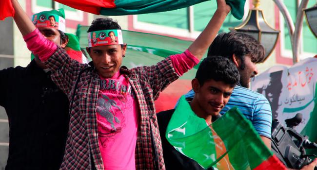 Young people hold country flags above their heads during an event outdoors