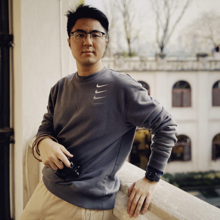 Zi Huang stood on balcony with camera in hand.