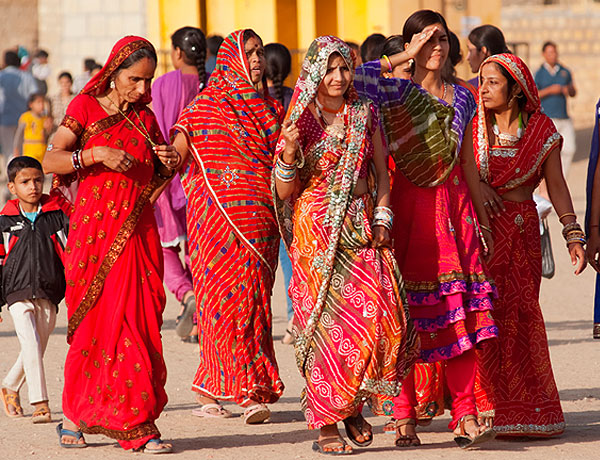 A group of woman of varying ages walk together in the street