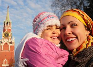 A mother cuddles her daughter to her cheek as they pose for a photo together on a chilly morning