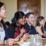 Students smiling seated in the Dining Room