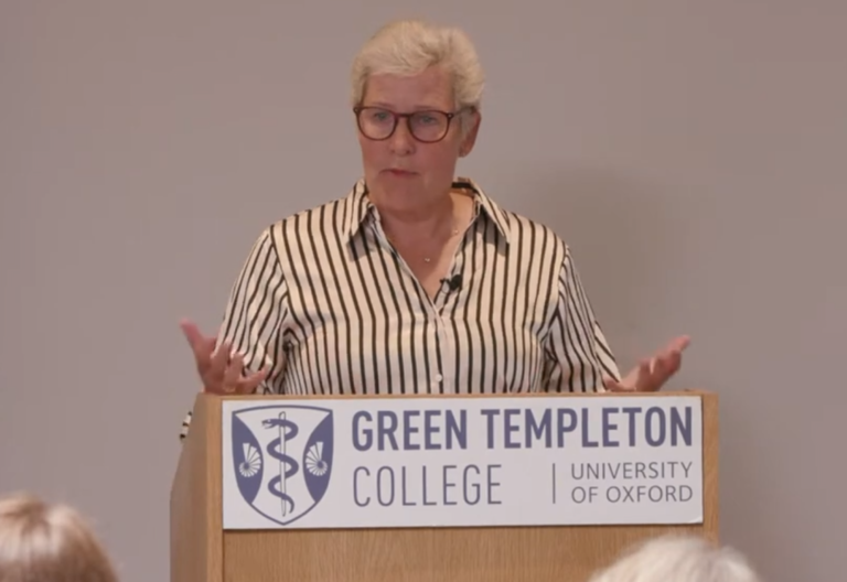 Anne Birgitte Albrectsen Speaking At Lectern With Green Templeton Logo Branding