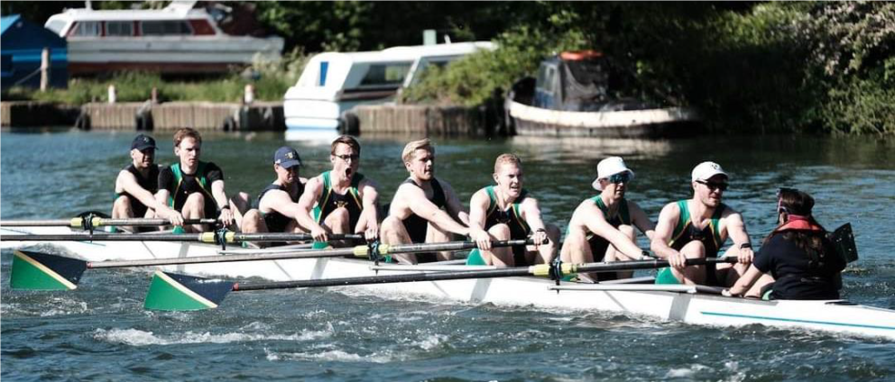 8 rowers and cox in boat on river with blades in sync