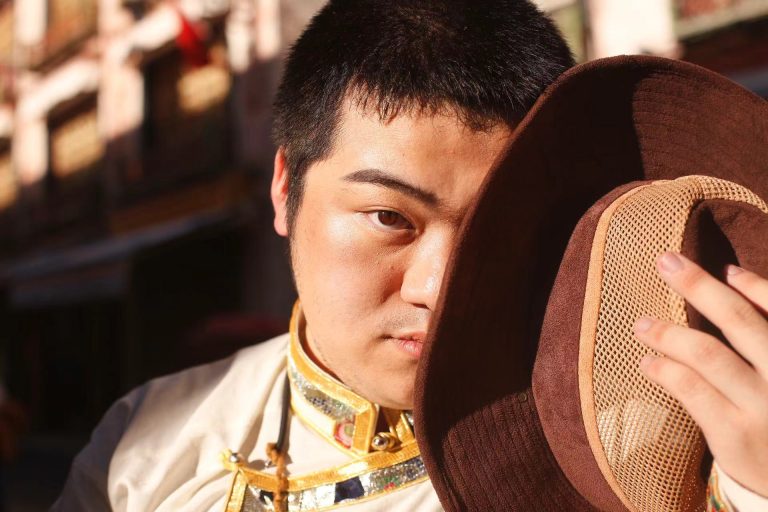 Hanting Su holding hat over half of their face