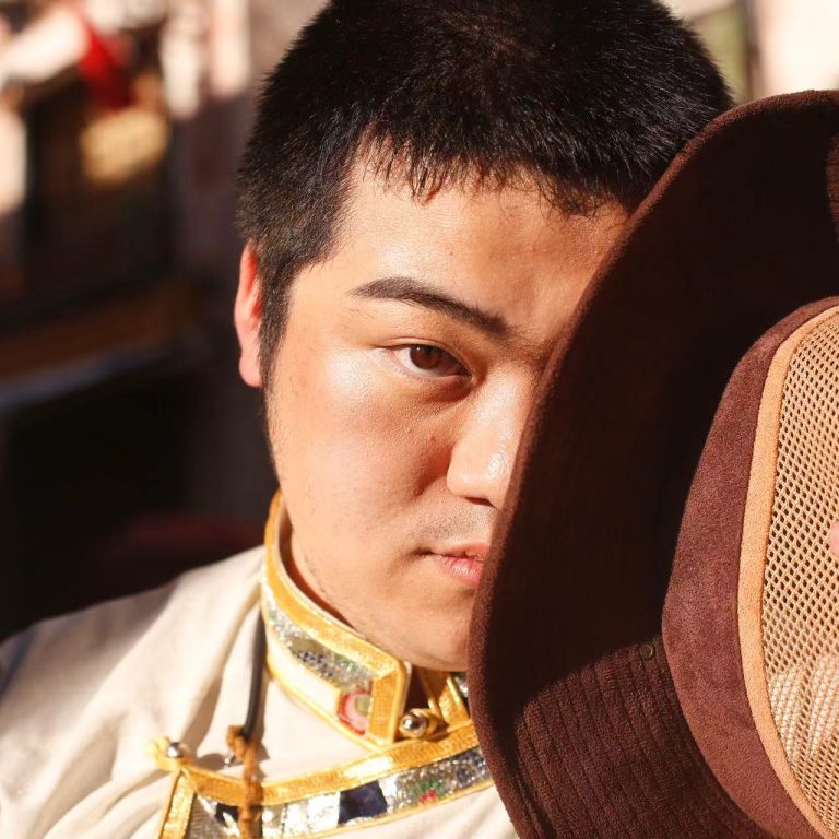 Hanting Su holding hat over half of their face