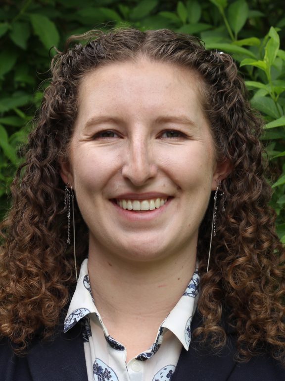 Katherine French in front of hedge