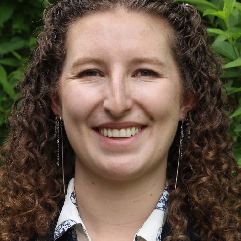 Katherine French in front of hedge