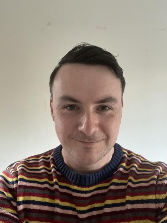 Daniel North headshot wearing stripped jumper