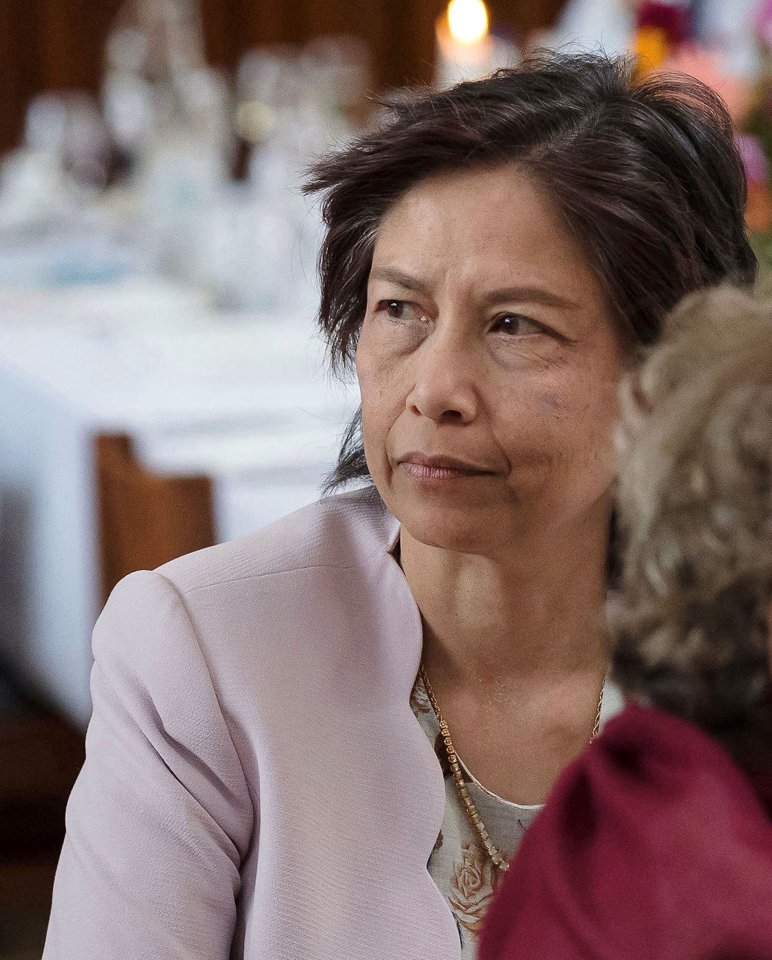 SanYuMay Tun pictured seated with tables behind