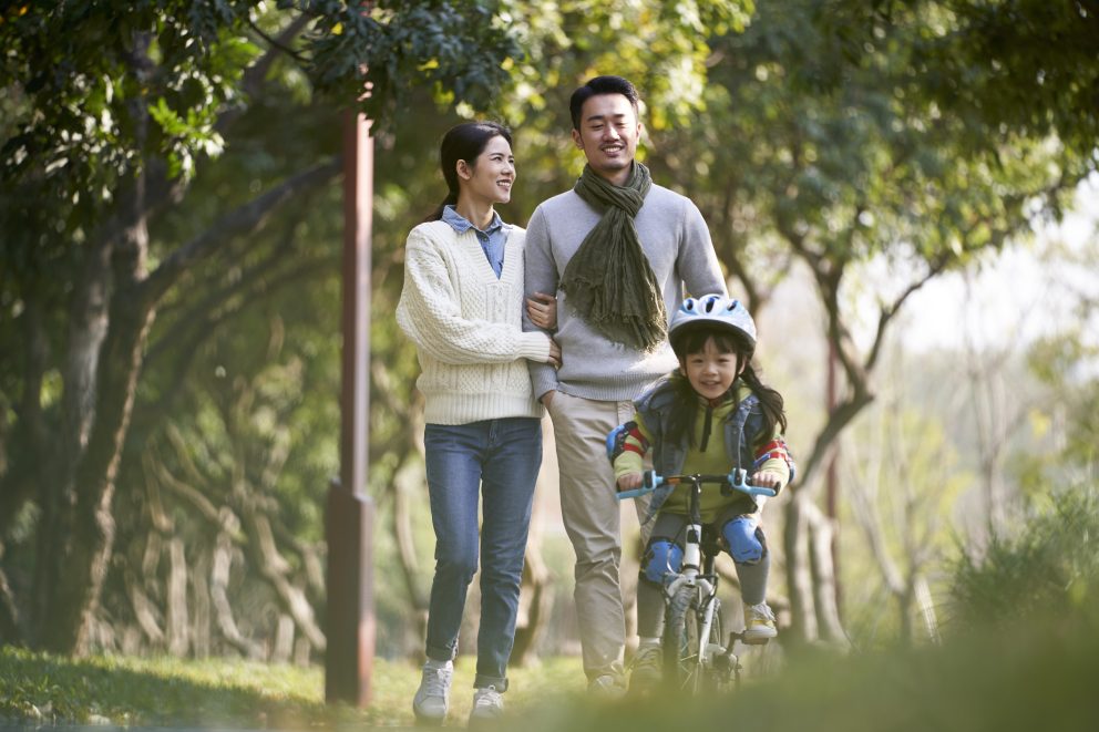 Young Asian Family With One Child Enjoying Outdoor Activity In Park