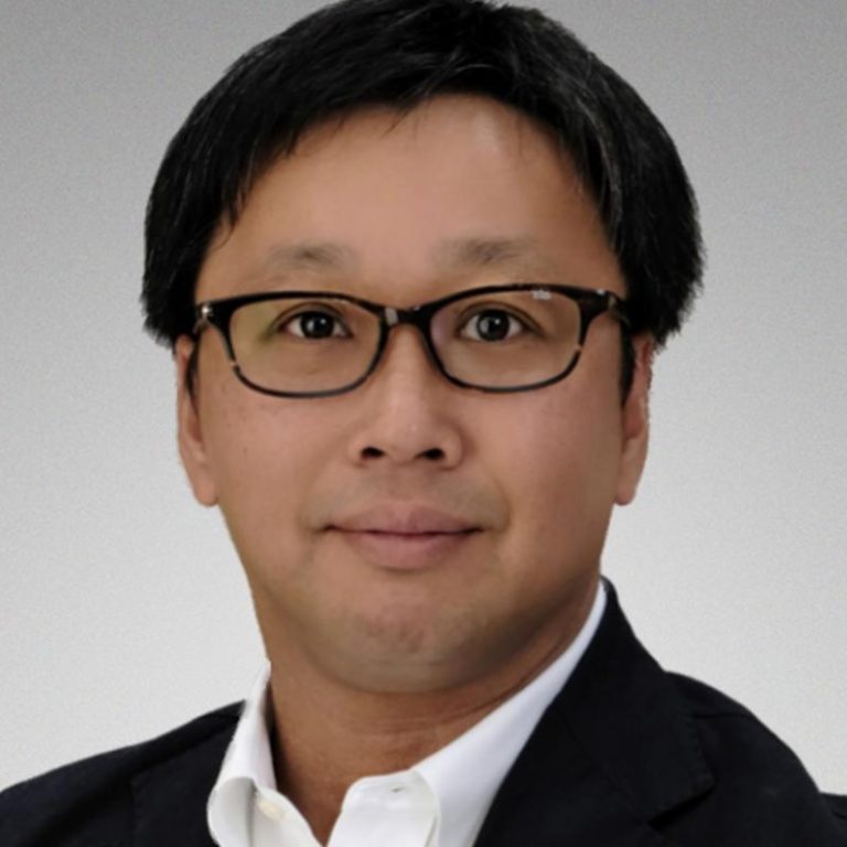 Jun Suzuki head and shoulders wearing glasses, white shirt and suit