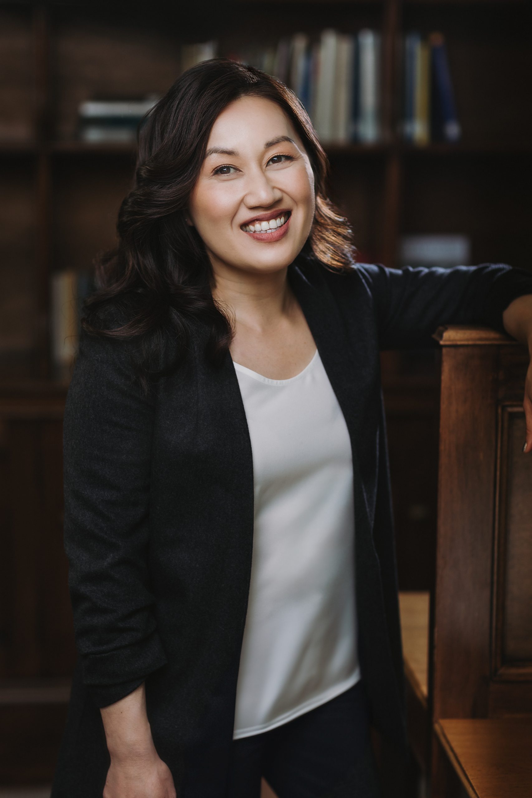 Selina Kaing stood in front of bookcase wearing black jacket 
