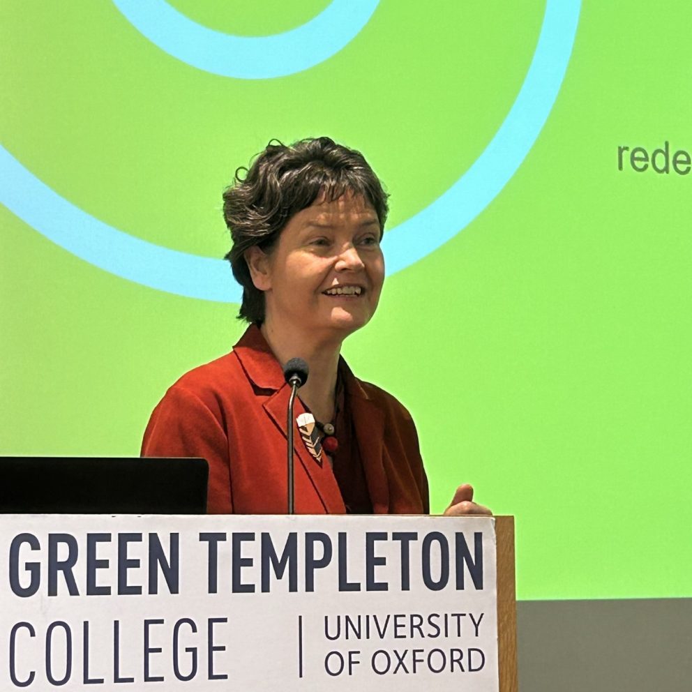 Kate Raworth Speaking At Green Templeton Branded Lectern With Yellow Projected Slide Behind