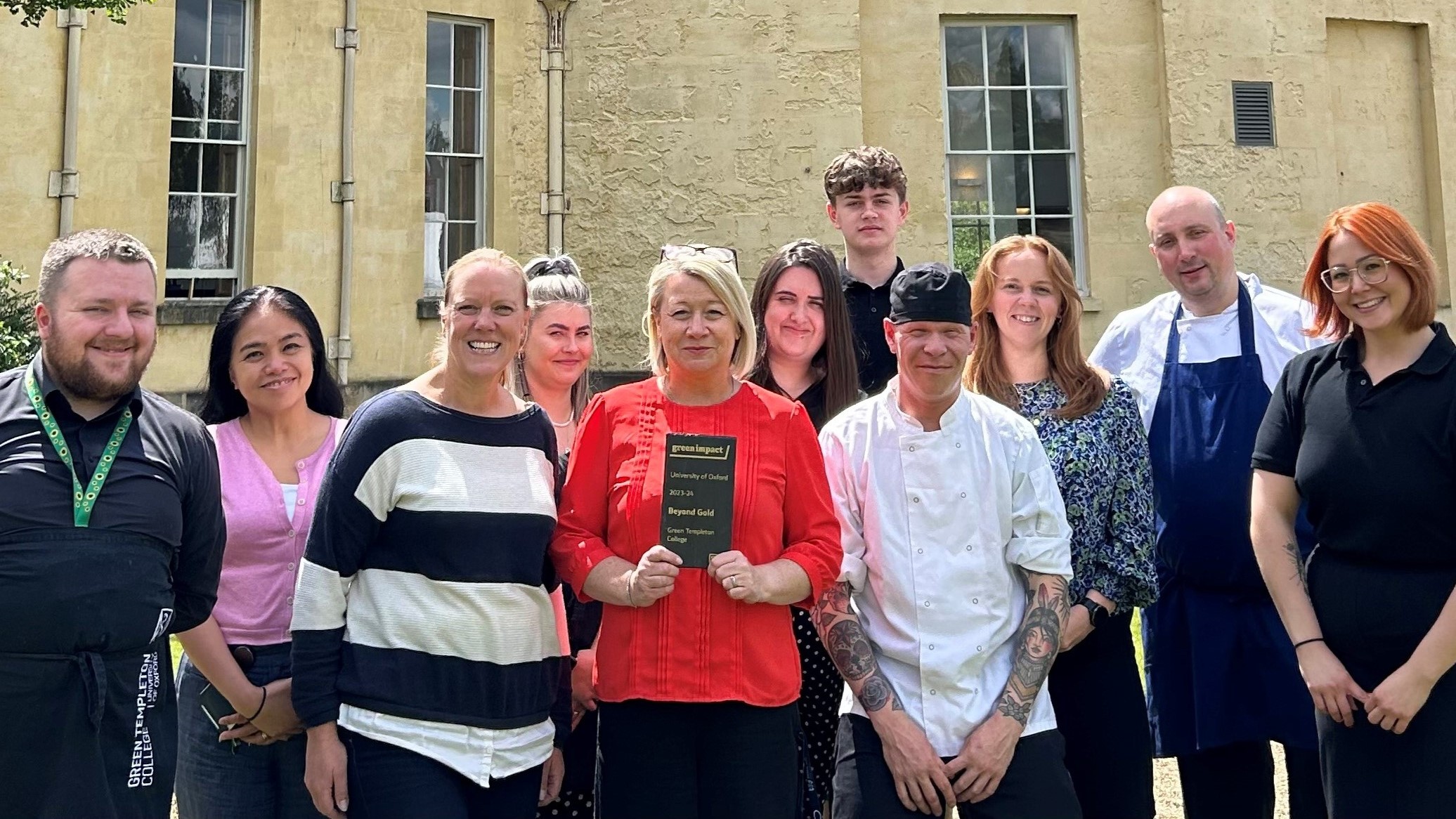Members Of Estates And Catering Team With Beyond Gold Award In Front Of Radcliffe Observatory On Sunny Day 16x9