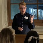 Alexander Hasson Speaking At Lectern