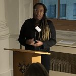 Kenzie Isaac Speaking At Lectern