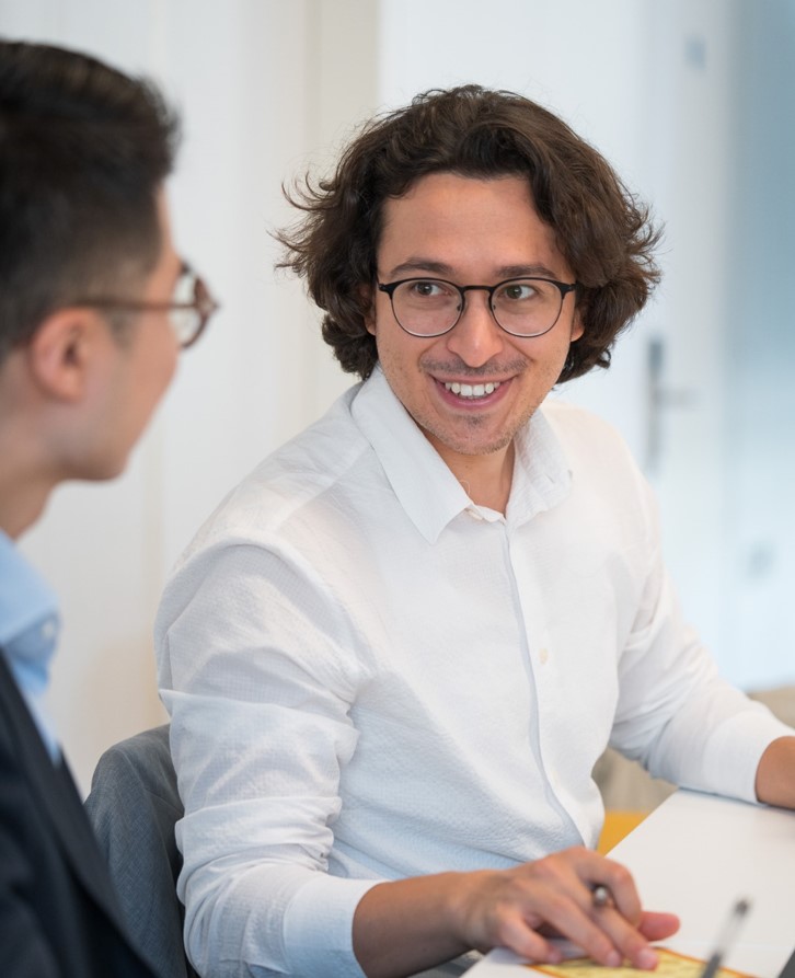 Yunus Isik Pictured Smiling At Colleague Seated