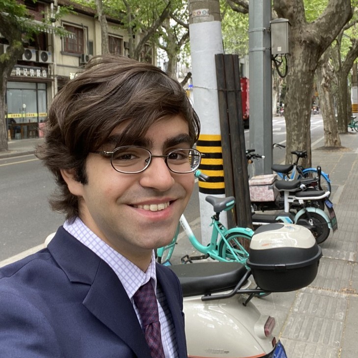 Rayan Mama in street with trees, bikes and mopeds in background