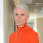 Jo Human wearing orange top looking at camera