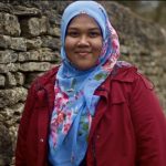 Rabeah Abdul Razak wearing red coat and blue floral headscarf