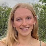 Evelyn Murrell Headshot in front of greenery.
