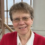Julie Saunders Profile Pic In Light Blouse And Red Cardigan Wearing Glasses By Radcliffe Observatory Tower Room Stairs