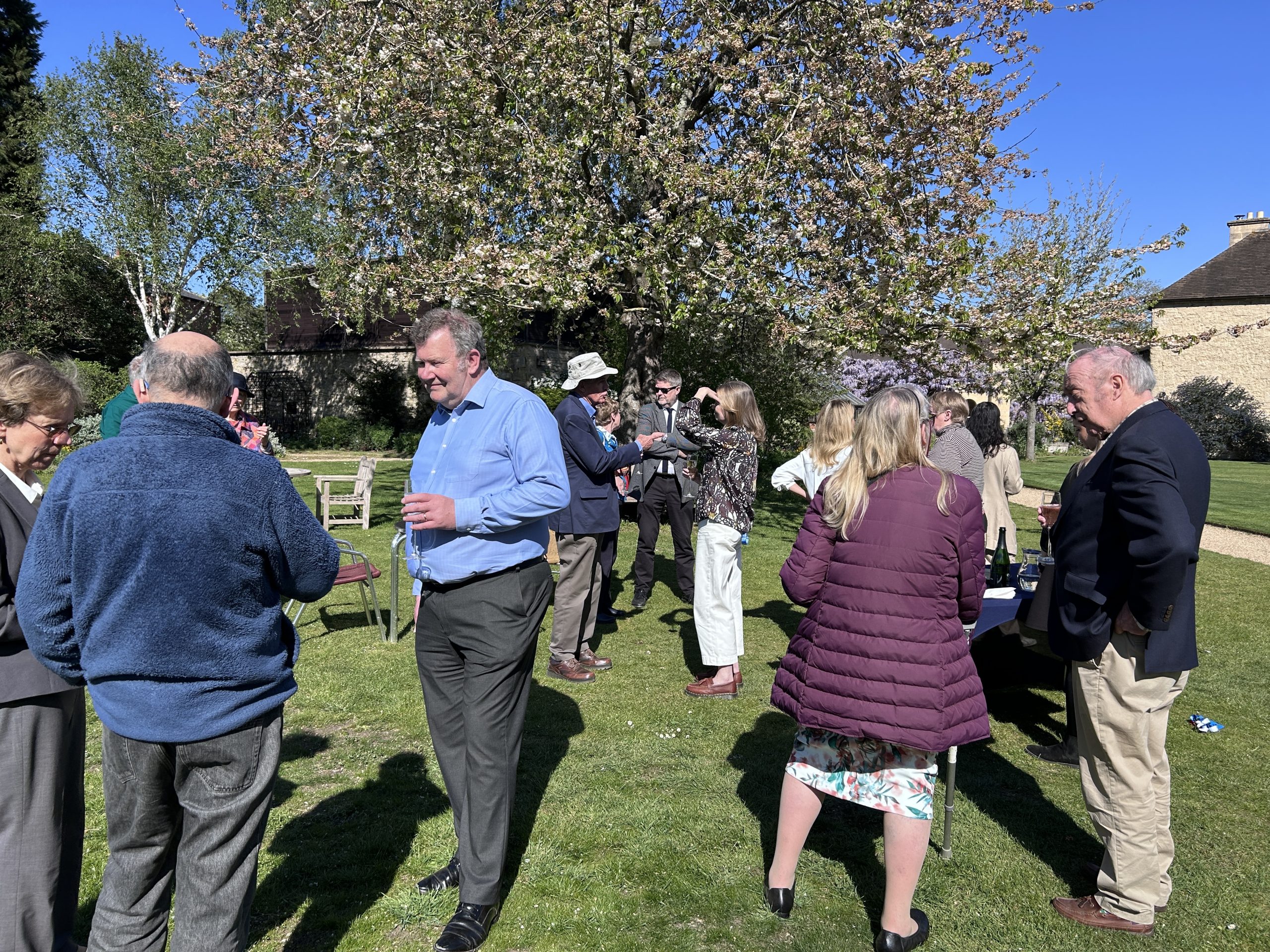 Group of people in college gardens enjoying Legacy society reception